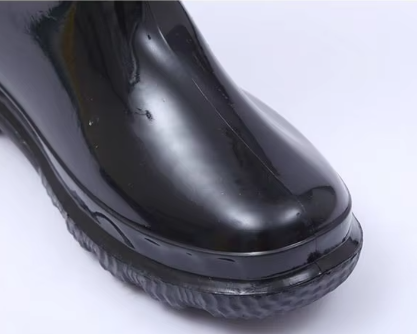 a092bfdc-7822-4703-8756-0930a4d9c5b3_closer-détail-de-la-pointe-arrondie-sur-botte-de-travail-imperméable-en-PVC-noir-brillant-et-chaud.png